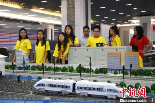 華裔青少年操作高鐵運行沙盤系統(tǒng)，模擬車站值班員接發(fā)列車。　朱柳融 攝
