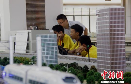  在教師指導下，華裔青少年操作高鐵運行沙盤系統(tǒng)，模擬車站值班員接發(fā)列車。 朱柳融 攝