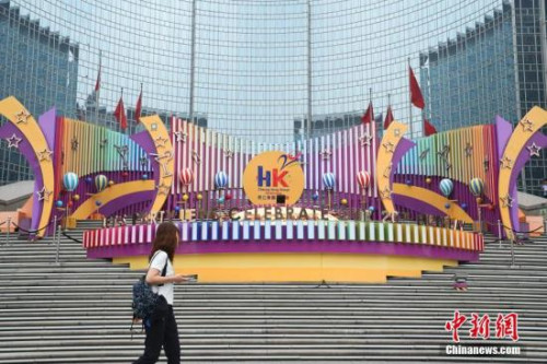 6月28日，市民從位于北京王府井東方廣場的一處慶祝香港回歸20周年的裝飾前走過。7月1日，香港特別行政區(qū)政府將迎來成立20周年紀(jì)念。<a target='_blank' >中新社</a>記者 侯宇 攝