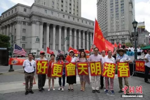 當(dāng)?shù)貢r間6月25日，美東各界華僑華人慶祝香港回歸二十周年大會在紐約曼哈頓弗利廣場舉行。圖為參會華人華僑打出“香港明天會更好”標(biāo)語。<a target='_blank' >中新社</a>記者 廖攀 攝