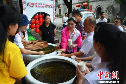 圖為游客爭(zhēng)相品嘗高山云霧茶?！∪~茂 攝