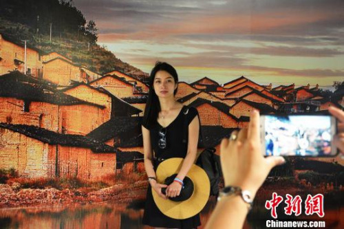 圖為游人美景前留影?！∪~茂 攝
