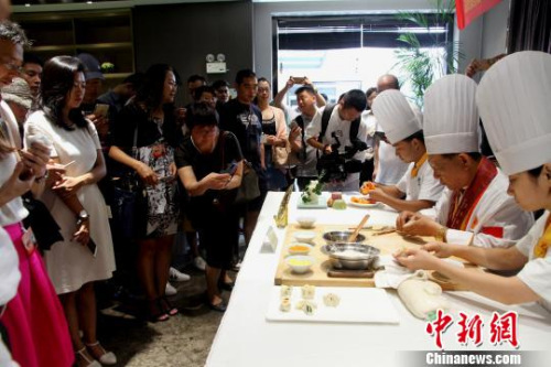 圖為烹飪大師現(xiàn)場廚藝表演，令華裔青年贊不絕口?！〈藜衙?攝