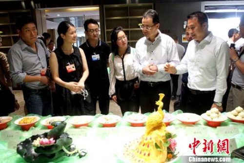  圖為華裔青年在參觀中華美食廚藝?！〈藜衙鳌z