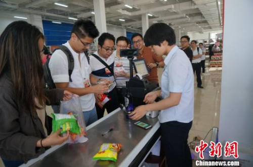 圖為華裔青年排隊為購買的進口商品付賬?！№n章云 攝