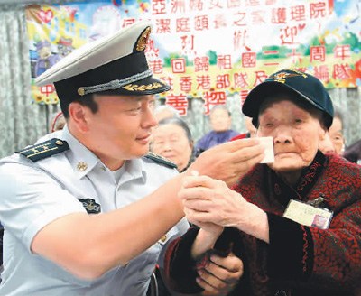 遼寧艦編隊與駐香港部隊官兵7月10日下午前往香港亞洲婦女協(xié)進會頤養(yǎng)之家護理院看望并慰問老人。已經(jīng)在護理院住了18年的110歲老人謝月瓊，興奮地豎起大拇指，留下了激動的淚水。圖為遼寧艦編隊官兵細心地為老人擦去淚水。 　　辜雨晴攝