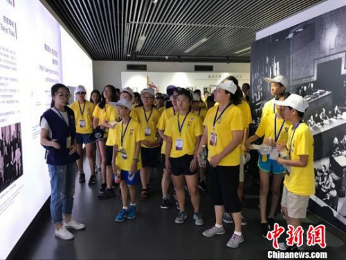 華裔師生參觀紀(jì)念館展廳，聽工作人員講解歷史。 江蘇省僑辦