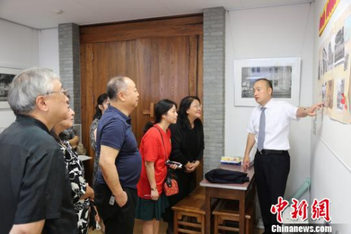 圖為橫濱山手中華學(xué)校校長張巖松(右一)向嘉賓們介紹百年校史?！∫ǜ?攝