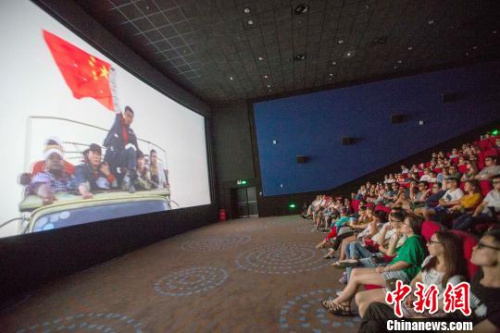 資料圖：影片《戰(zhàn)狼》中冷鋒（男主角）舉著中國國旗安全通過交戰(zhàn)區(qū)?！堅啤z