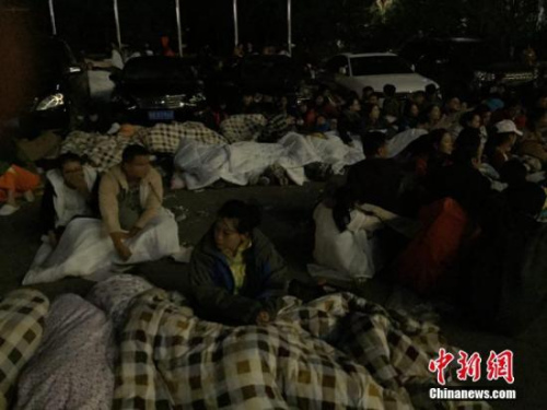 圖為九寨溝景區(qū)內(nèi)，許多游客不敢繼續(xù)待在酒店內(nèi)，裹著厚衣服和毛毯來到街上席地而睡。 徐廣 攝