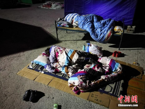 8月10日凌晨2時許，記者抵達四川阿壩州九寨溝地震災區(qū)，隨即走進永樂鎮(zhèn)清平三村村委會、梨花廣場避難場所探訪，眾多民眾為躲避余震，一家人擠在一起睡在露天廣場，深夜氣溫僅有13度。<a target='_blank'  >中新網</a>記者 陳文 攝