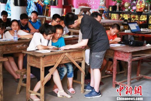 圖為美國華裔少年為當?shù)睾⒆觽兘淌谟⒄Z?！￡愃?攝