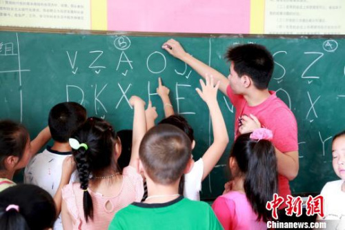 圖為美國華裔少年為當?shù)睾⒆觽兘淌谟⒄Z?！￡愃?攝