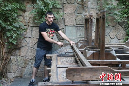 圖為：德國漢諾威孔子學(xué)院學(xué)生體驗(yàn)四桶茶葉揉捻機(jī)?！⊥鯙t婧 攝