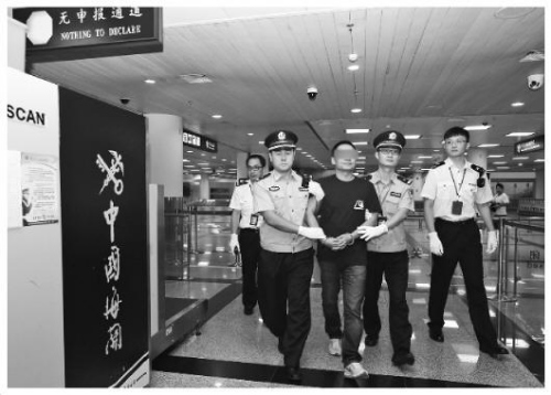 圖為拱北海關(guān)緝私警察將紀(jì)某押出機場海關(guān)通道。張建林 攝