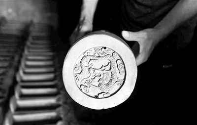 古都國華琉璃廠經(jīng)理孫宏利展示琉璃半成品上刻有的圖案。停產(chǎn)后，廠子只能將部分半成品運(yùn)到山西進(jìn)行二次加工