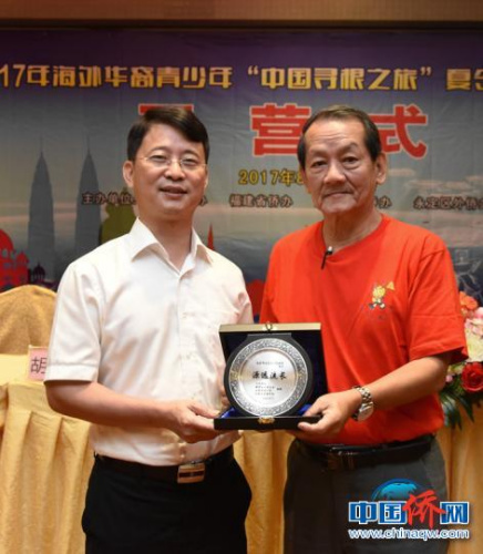 圖為王小慶代表永定區(qū)委、區(qū)政府接受羅良斌贈送的紀(jì)念品?！⒂懒?攝
