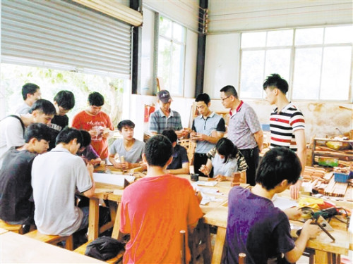 李炳祺在學(xué)校給同學(xué)們上古典家具制作實踐課。