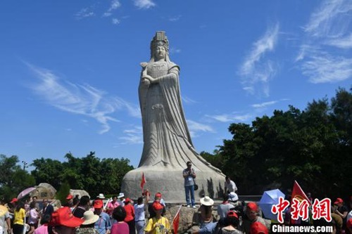 圖為嘉賓在媽祖石像前拍照?！蚊?攝