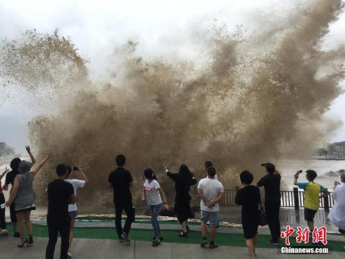 9月14日，游客們在溫嶺三岙觀景平臺觀浪拍照。當天，第18號超強臺風“泰利”靠近，浙江臺州溫嶺市石塘鎮(zhèn)金沙灘巨浪滔天，游客們在三岙觀景平臺觀浪和拍照片。<a target='_blank' >中新社</a>記者 張琦 攝