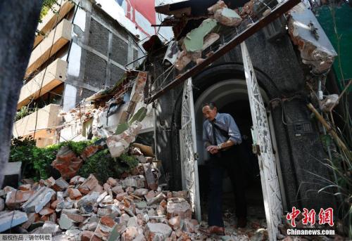 墨西哥城Condesa區(qū)，一名男士從樓房里出來(lái)，門外是滿地的房屋瓦礫，建筑已成廢墟。