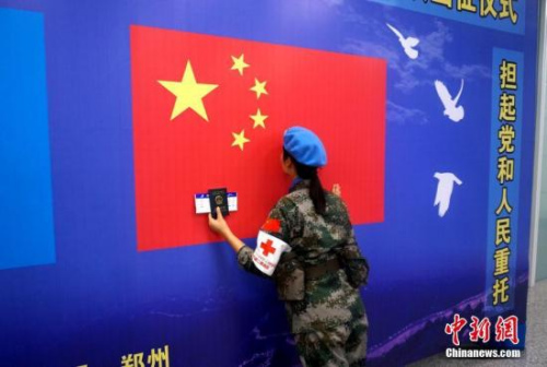 一名維和女兵出征前親吻五星紅旗。 李志全 攝