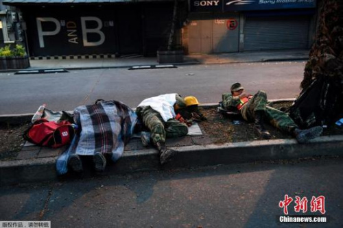 圖為精疲力盡的救援士兵席地而睡。