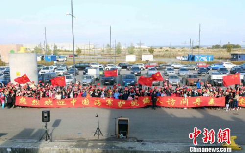 當?shù)貢r間9月25日，中國海軍第二十六批護航編隊訪問丹麥。圖為丹麥華人華僑拉起巨大橫幅，揮舞國旗歡迎編隊到訪?！×纸　z
