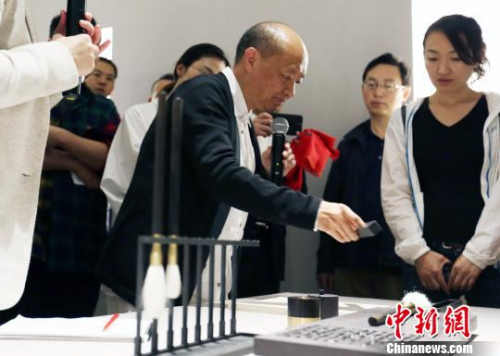 9月29日下午，“盧志榮‘合一’宏觀與微觀世界的緘默”展覽在北京達(dá)美藝術(shù)中心開幕。此次展覽亦是達(dá)美藝術(shù)中心的首展，將持續(xù)向公眾開放至11月29日。圖為盧志榮在展覽現(xiàn)場向媒體展示他的作品。　鐘欣 攝