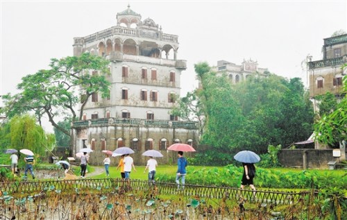盡管天下著小雨，游客仍冒雨參觀開平自力村碉樓。伍安平 攝
