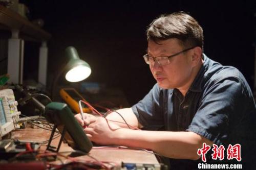 鄧建軍在維修設(shè)備。 江蘇常州黑牡丹(集團)股份有限公司供圖。