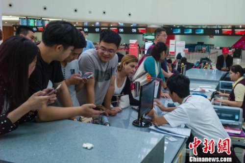 圖為?？诿捞m國際機場航站樓內服務臺聚集了前來改簽問詢的旅客?！●樤骑w 攝