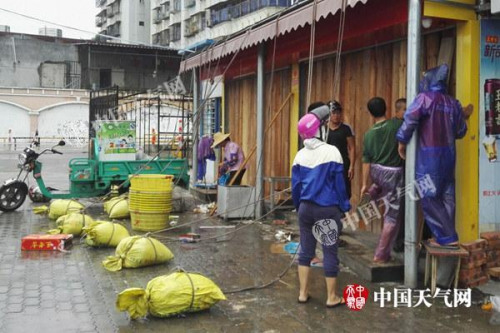 15日白天，廣東湛江風雨逐漸明顯，市民正在加固門窗。(圖/殷美祥)