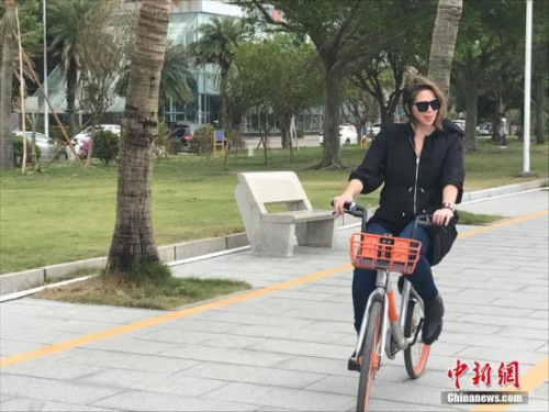 來華報道十九大的外國記者發(fā)現(xiàn)街頭隨處可見“共享單車”。外國記者們仔細詢問用法，下載軟件“試騎”，并表示要將這個“新鮮事”播報給本國讀者。圖為來自阿根廷的記者波戈里萊斯在珠海街頭試騎共享單車。 肖欣 攝