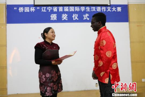 遼寧省外事(僑務(wù))辦公室副主任趙冰冰(左)為獲特等獎國際學(xué)生頒獎?！∩虻畛?攝