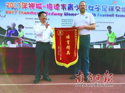 英國(guó)梅德韋市安卡利亞球會(huì)會(huì)長(zhǎng)李·威利斯金向禪城區(qū)文化體育局代表贈(zèng)予錦旗。梁志毅 攝