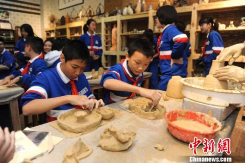 圖為學(xué)生們?cè)谡J(rèn)真體驗(yàn)陶藝。