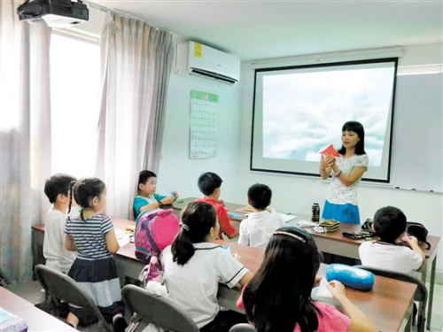陳小清給學(xué)生上剪紙課。