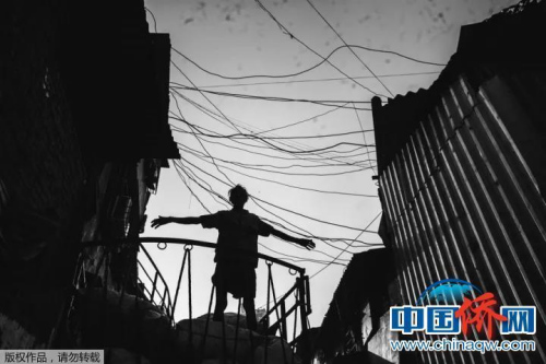 “相機攝”印度達拉維貧民窟，貧民窟中的一個搬運工，不知道他這個動作是為了伸展一下四肢還是有貨物丟了下來。但在這一刻，我仿佛看見了上帝。