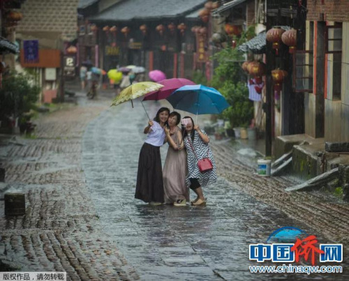 “相機攝”湖南永州市零陵老街，三位美女在雨中的老街玩自拍。