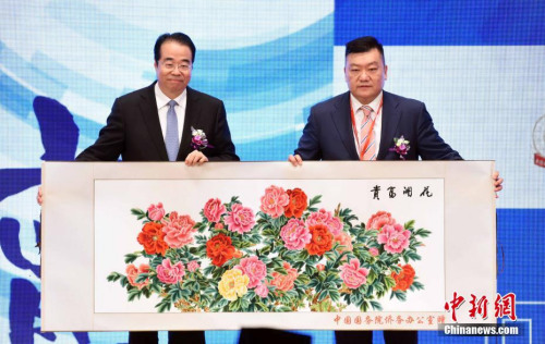 11月23日，中國(guó)國(guó)務(wù)院僑務(wù)辦公室黨組書(shū)記、副主任許又聲（左）向香港潮州商會(huì)會(huì)長(zhǎng)胡劍江致送紀(jì)念品。<a target='_blank' >中新社</a>記者 譚達(dá)明 攝