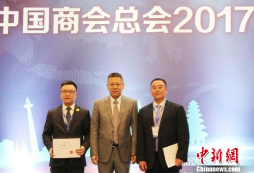 圖為中國駐印尼大使館經(jīng)商處公參王立平(中)為新當選的印尼中國商會總會主席宮本才(右)和常務副主席兼理事會主席劉城(左)頒發(fā)聘書?！×钟纻?攝