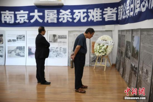 12月13日，悉尼僑界舉行南京大屠殺死難者國家公祭日悼念活動，30多個社團(tuán)的近百名華僑華人參加。圖為與會者參觀“南京大屠殺”圖片展。 <a target='_blank' >中新社</a>記者 陶社蘭 攝