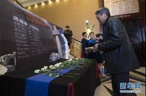 一名男子在紀(jì)念南京大屠殺80周年追思會上獻(xiàn)花