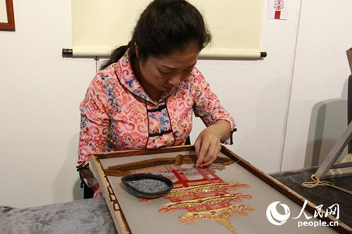 潮汕刺繡項(xiàng)目傳承人洪裕靜借鑒了雙面繡技法，正在進(jìn)行雙面珠繡的創(chuàng)作。(攝影：吳玉潔)
