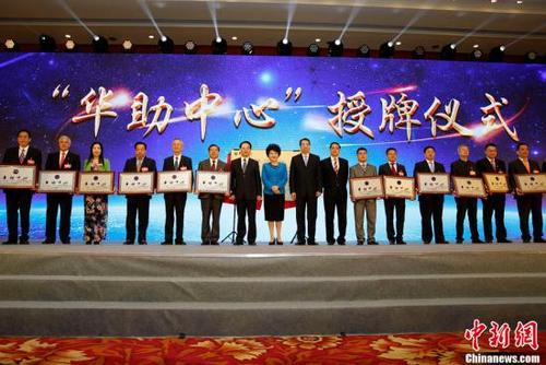 月29日，國務(wù)院僑辦主任裘援平(左八)，黨組書記、副主任許又聲(左九)、副主任譚天星(左七)、副主任郭軍(左十)為第四批15家“華助中心”授牌。當(dāng)日，中國國務(wù)院僑務(wù)辦公室、中國海外交流協(xié)會(huì)在北京舉辦“為僑服務(wù)日”活動(dòng)，來自83個(gè)國家和地區(qū)的537位僑界代表及國內(nèi)相關(guān)部門負(fù)責(zé)人共慶中華人民共和國成立68周年。<a target='_blank' >中新社</a>記者 李慧思 攝