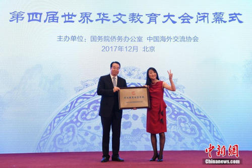 12月20日，第四屆世界華文教育大會(huì)在北京閉幕。圖為國(guó)務(wù)院僑務(wù)辦公室黨組書記、副主任許又聲(左)向法國(guó)小熊貓學(xué)校校長(zhǎng)羅堅(jiān)海外華文教育示范學(xué)校授牌。 <a target='_blank' >中新社</a>記者 崔楠 攝