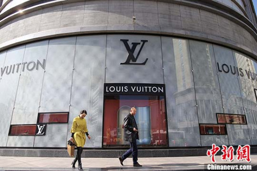 資料圖：民眾從法國(guó)奢侈品牌路易•威登（LV）店前經(jīng)過(guò)。（<a target='_blank' >中新社</a>記者 張?jiān)?攝）