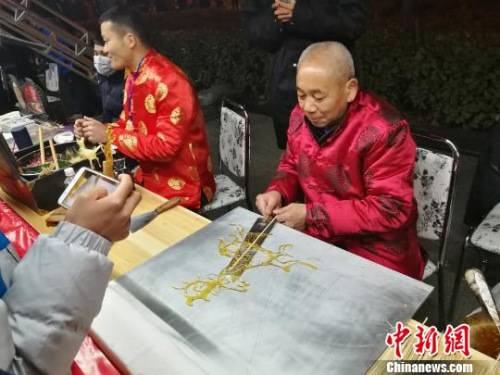 圖為非遺傳承人在制作唐人?！《w 攝