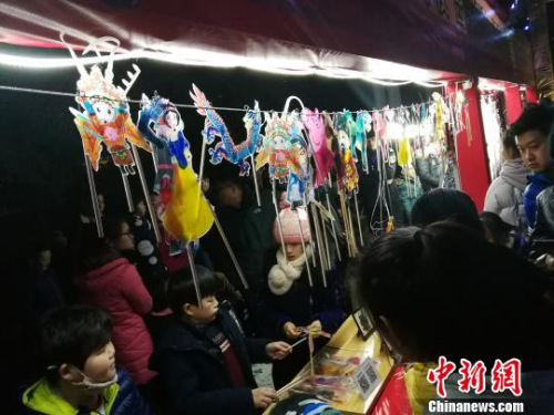 圖為捏糖人現(xiàn)場(chǎng)人頭攢動(dòng)?！《w 攝